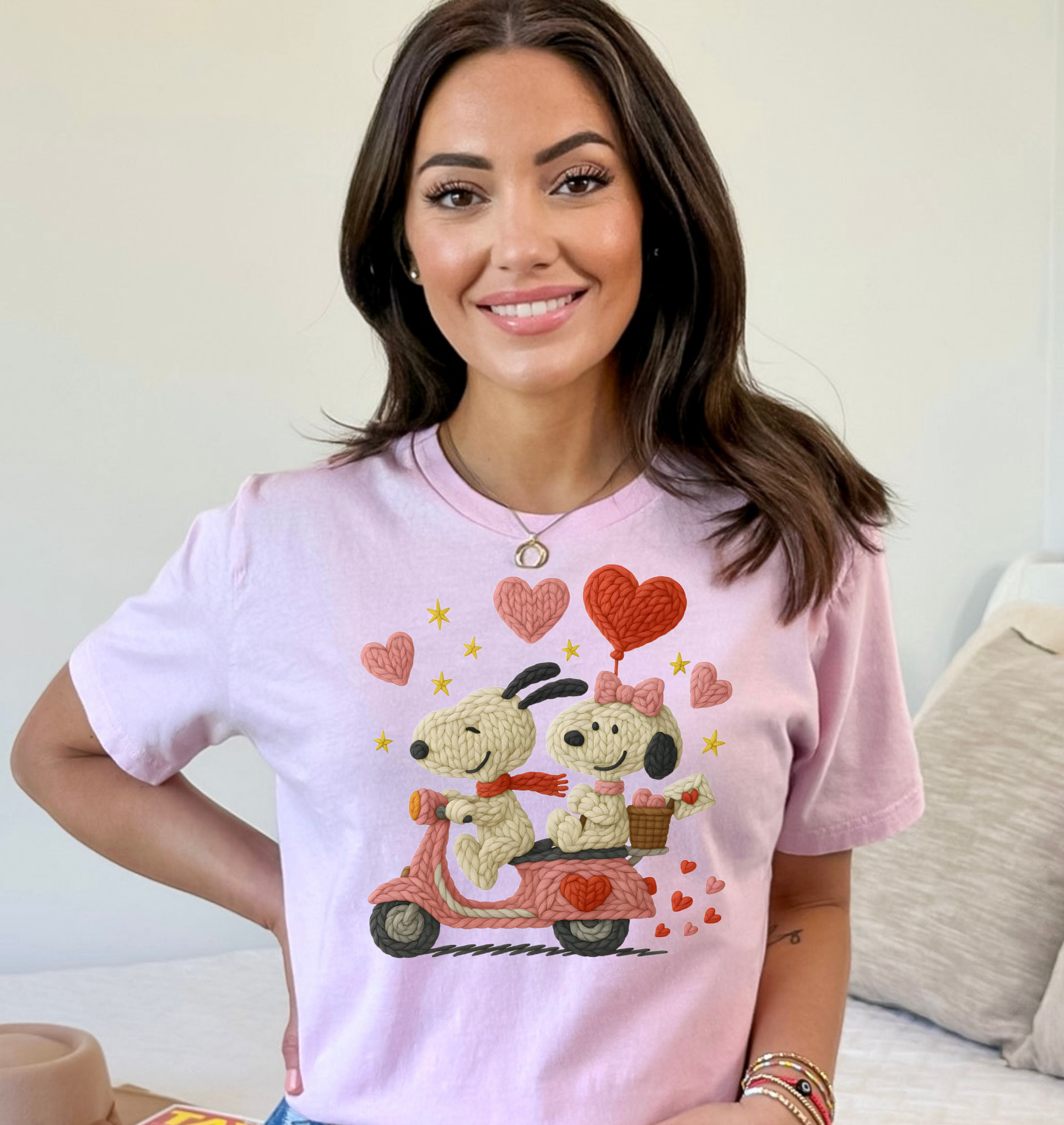 Woman wearing a pink t-shirt with cartoon characters and hearts, standing in a casual setting.
