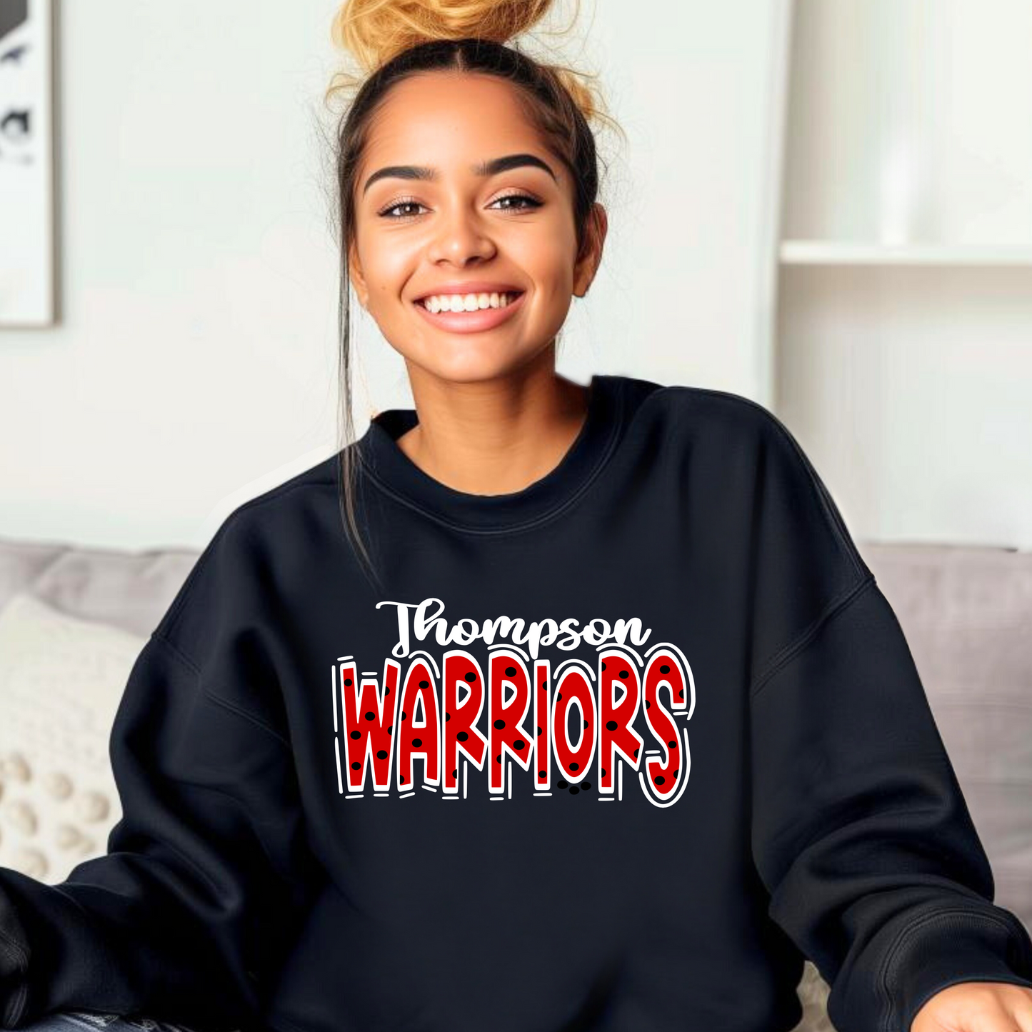 A person smiling, wearing a black sweatshirt with 'THOMPSON WARRIORS' text in red and white.