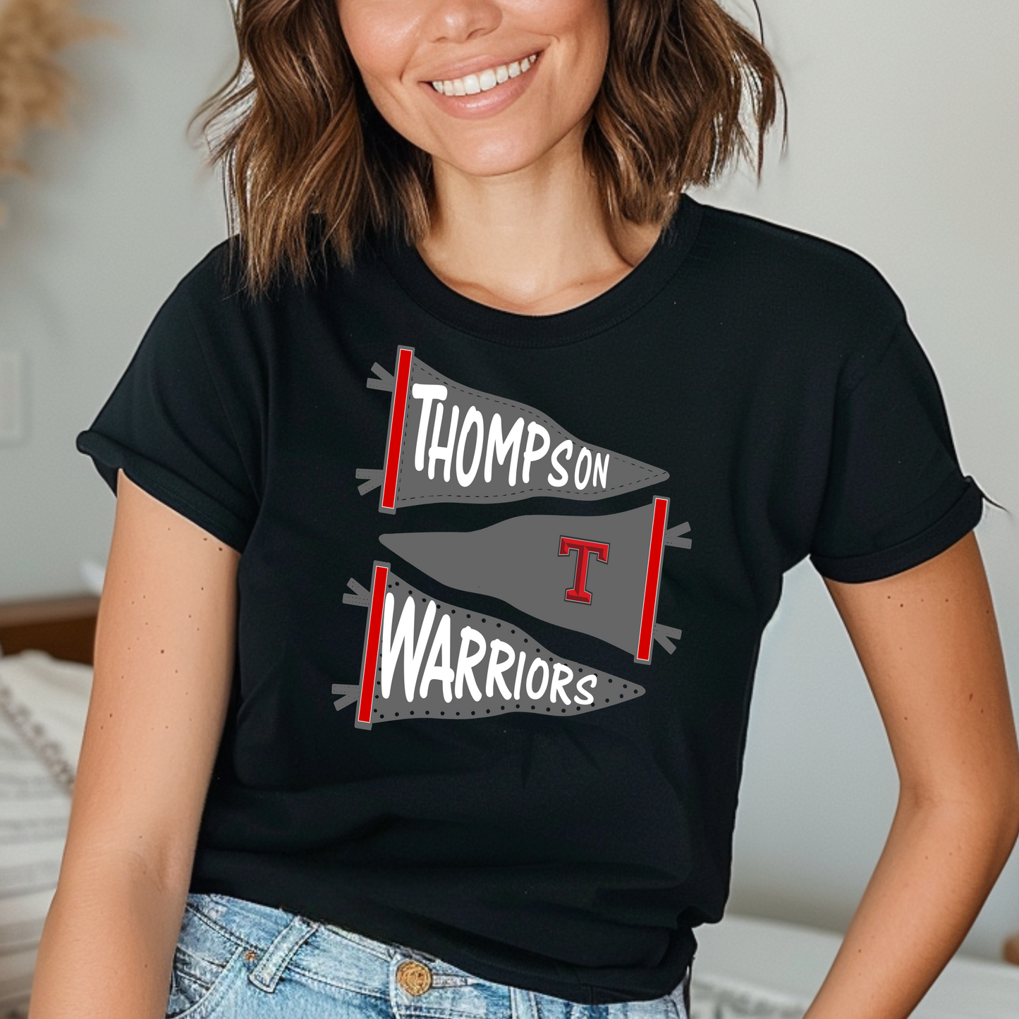 A person wearing a black 'THOMPSON WARRIORS' t-shirt with a graphic of a guitar on the front.